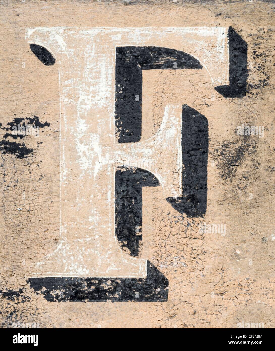 Dissolving letter F of a historical advertising lettering Stock Photo