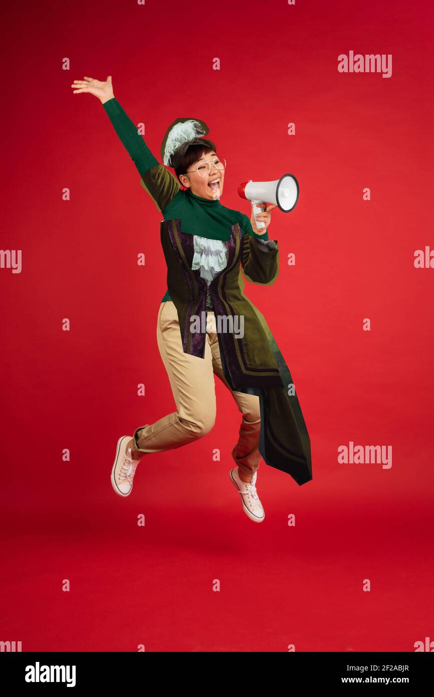 Asian woman with megaphone. Magazine style collage with model outfit mixed of different eras. Copyspace for ad. Trendy colors, modern and vintage, renaissansse fashion. Cintemporary art collage. Stock Photo
