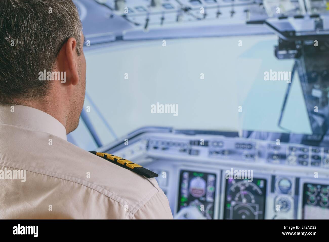Commercial airplane captain in the cockpit of a flying airplane Stock