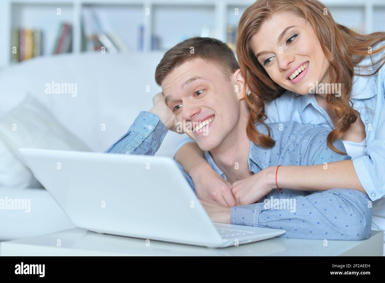 Portrait of young couple with laptop at home Stock Photo - Alamy