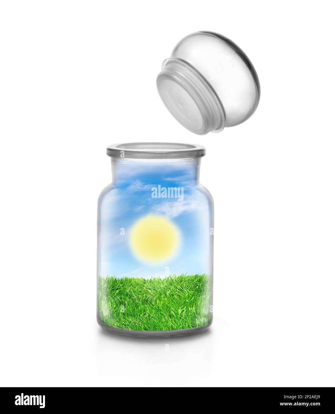 Sunny day over the grass landscape inside a chemical bottle on white background and flying topper. Funny ecological and sustainable concept. Stock Photo