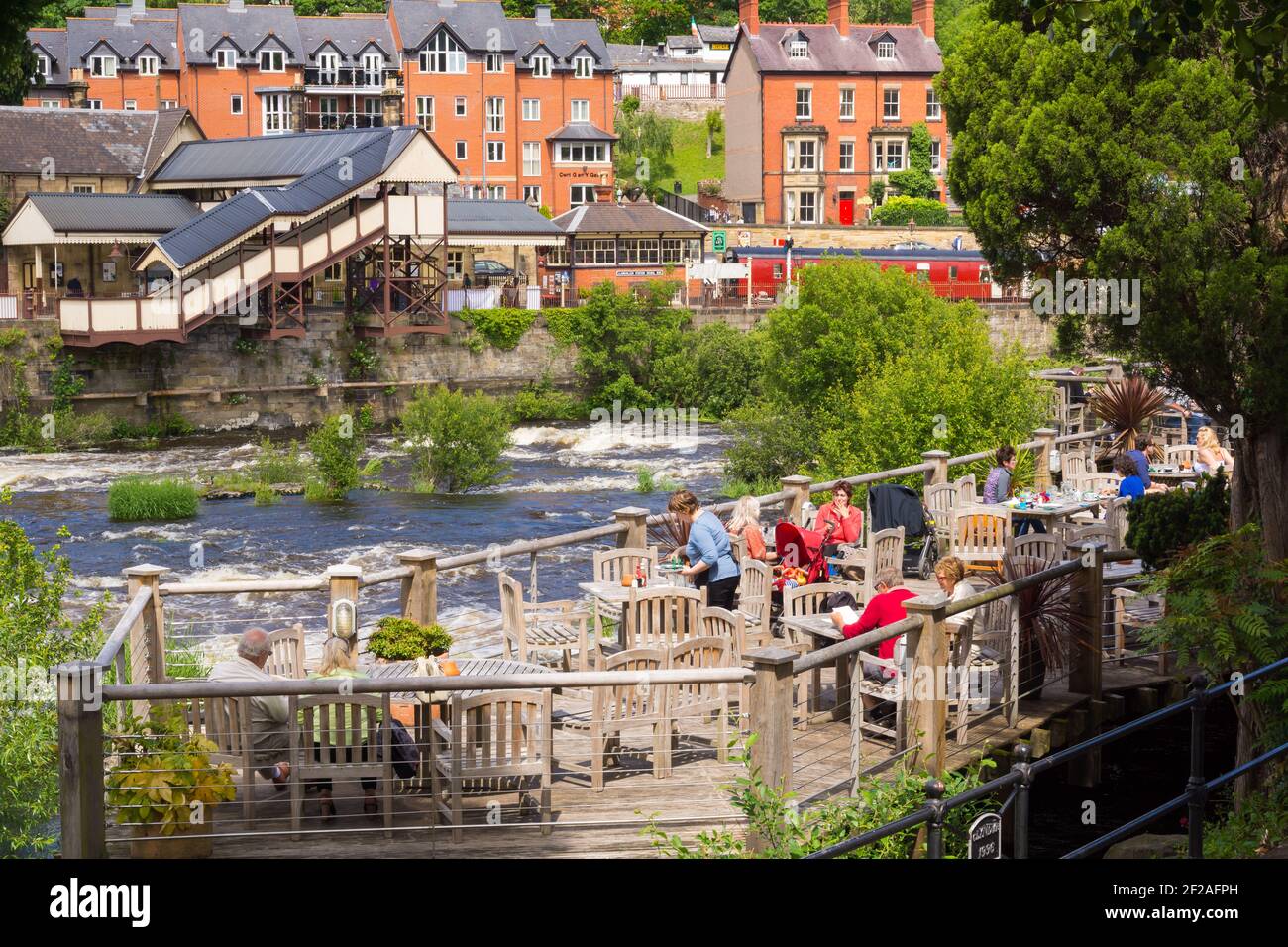 Open air decking and eating area at The Corn Mill a waterside pub and restaurant in Llangollen North Wales on the banks of the River Dee Stock Photo