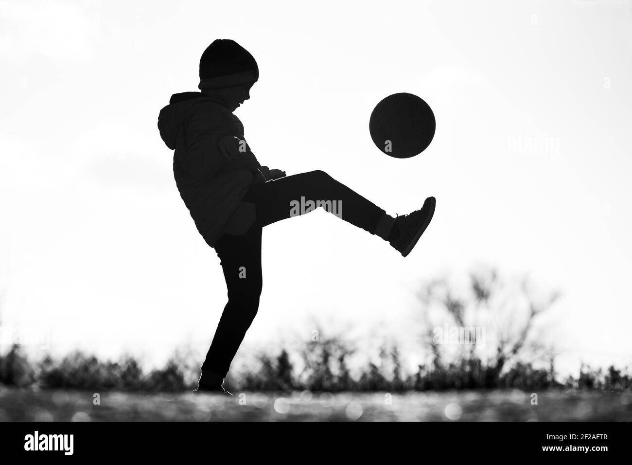 Silhouette Of Young Boy Playing Football Stock Photo Alamy