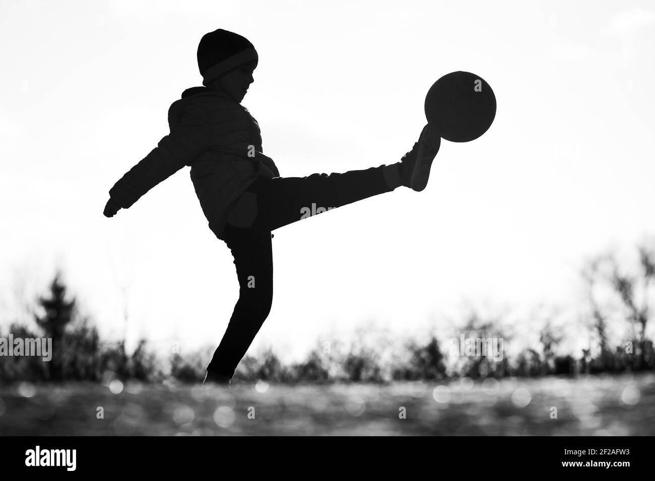 Silhouette Of Young Boy Playing Football Stock Photo Alamy