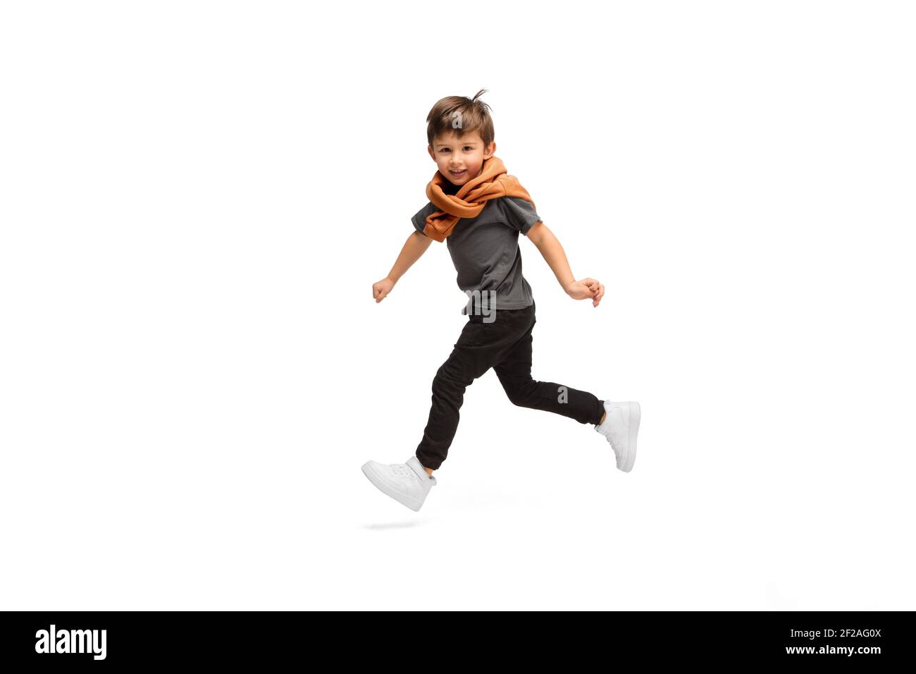 Jumping, running. Happy, smiley little caucasian boy isolated on white