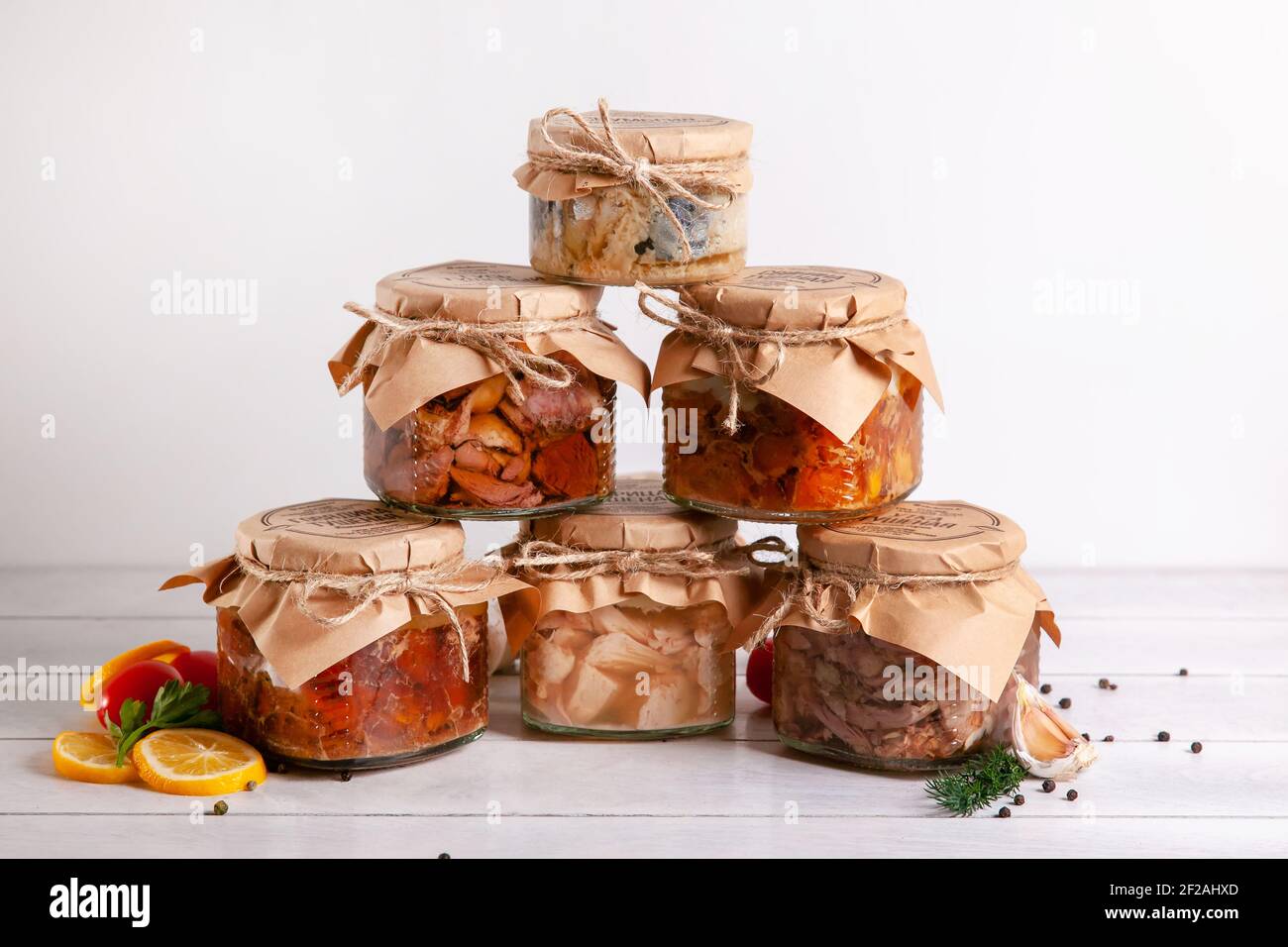 Homemade canned meat from farm poultry-goose, duck, chicken, pork and beef, canned fish from mackerel. A pyramid of glass cans with canned food. Stock Photo