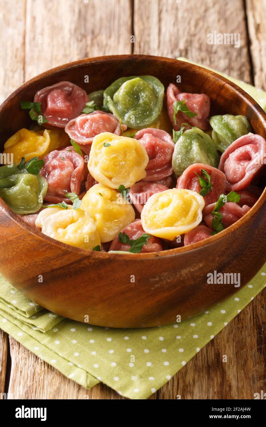 Italian pasta tortellini from colored dough close-up in a bowl on the table. vertical Stock Photo