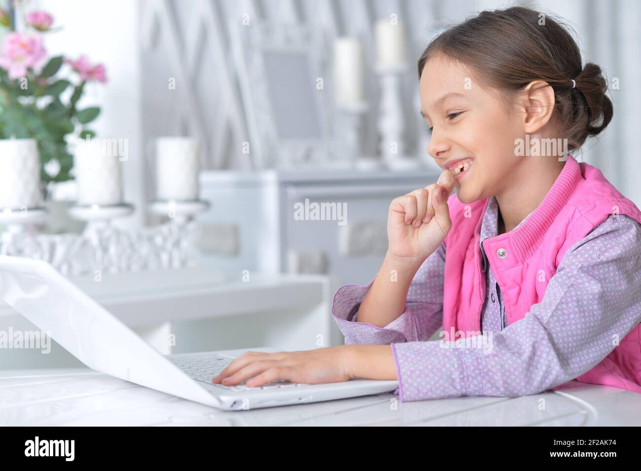 Portrait of cute little girl using modern laptop Stock Photo - Alamy