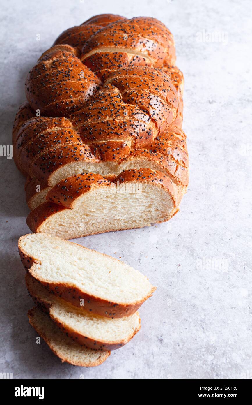 Freshly sliced loaf of challah bread with poppy seeds viewed from above. Stock Photo