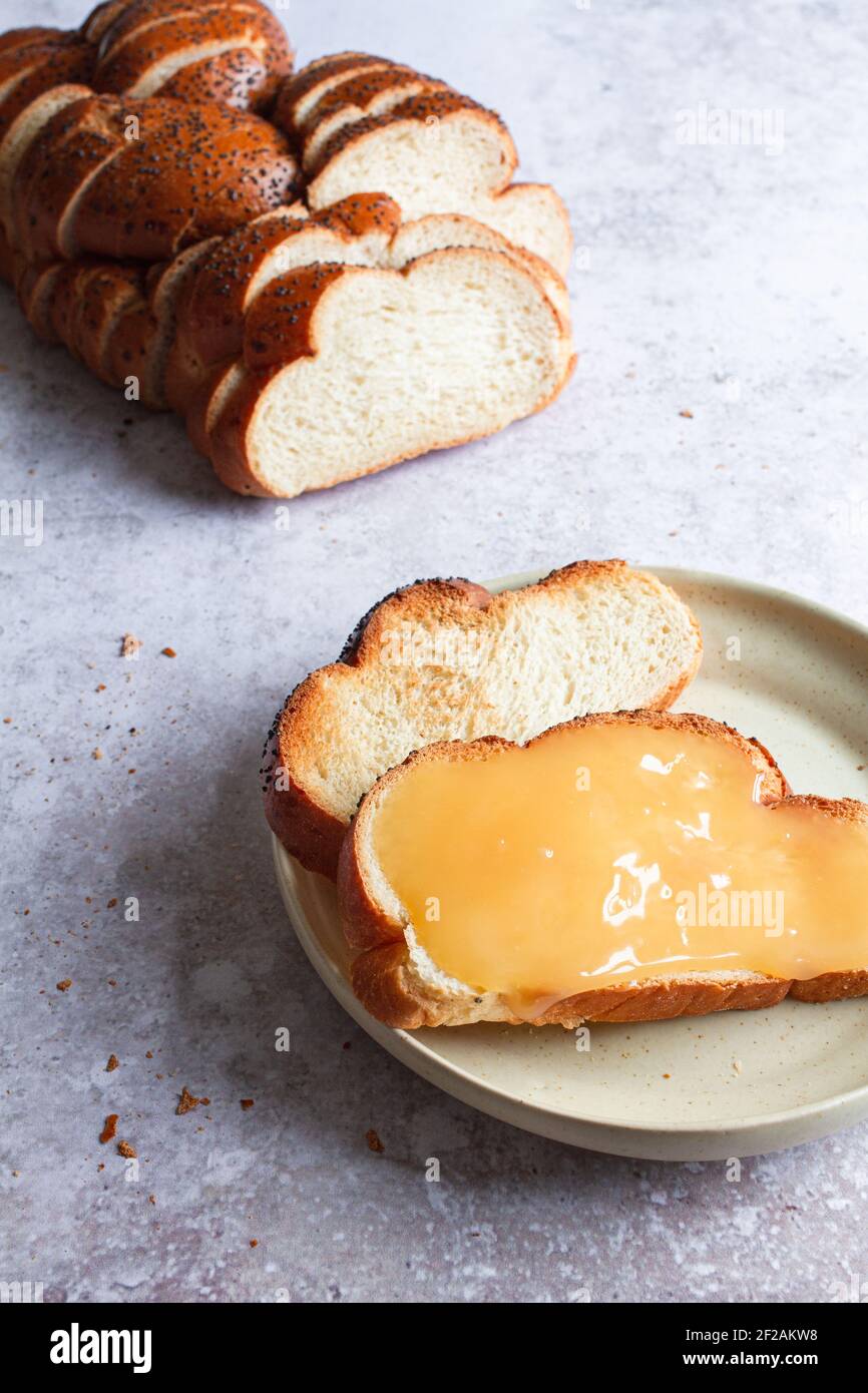 Freshly sliced challah bread loaf with two slices toasted and one spread with lemon curd. Stock Photo