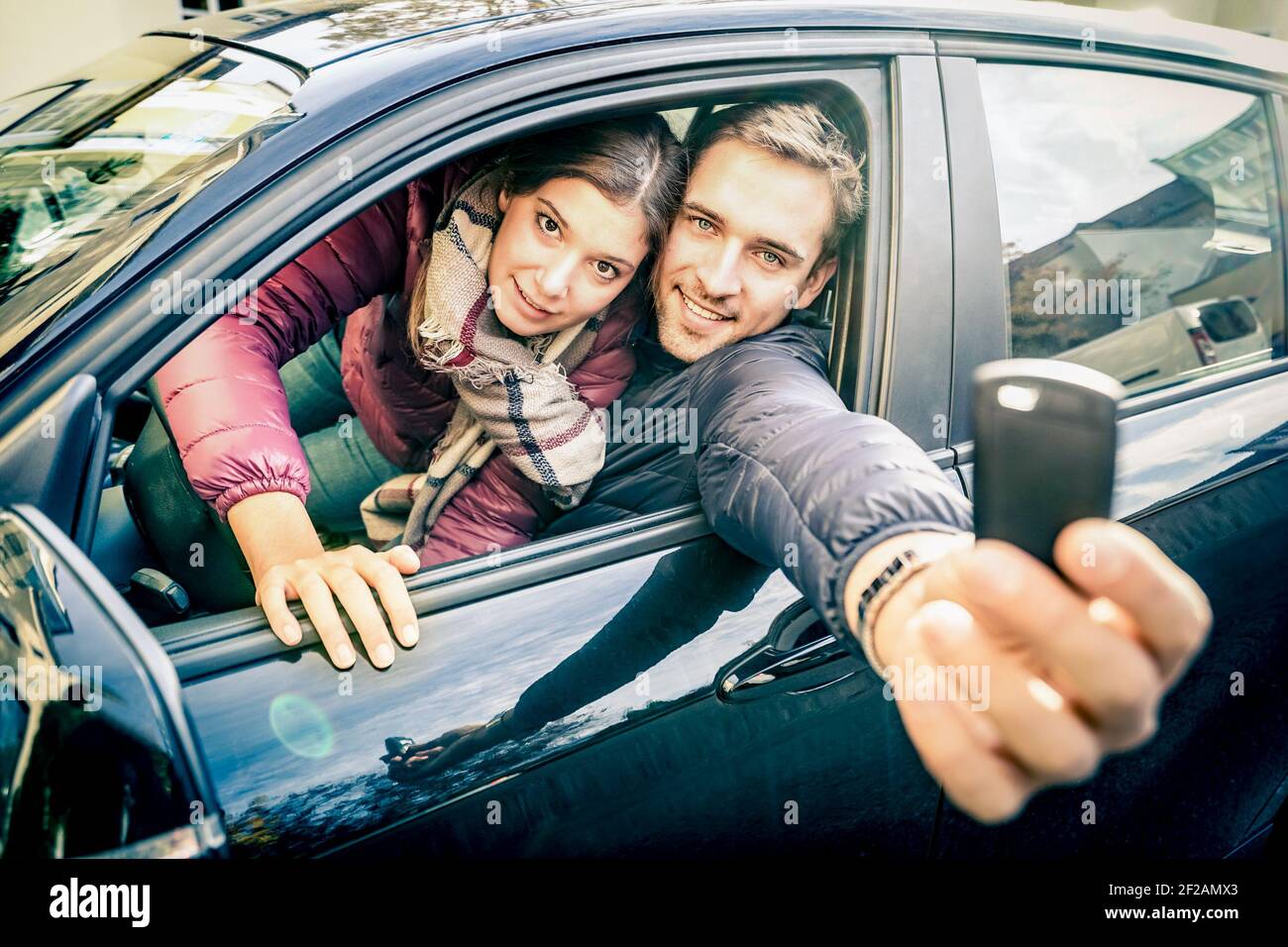 Happy couple at car rent showing electronic key ready for the next road ...