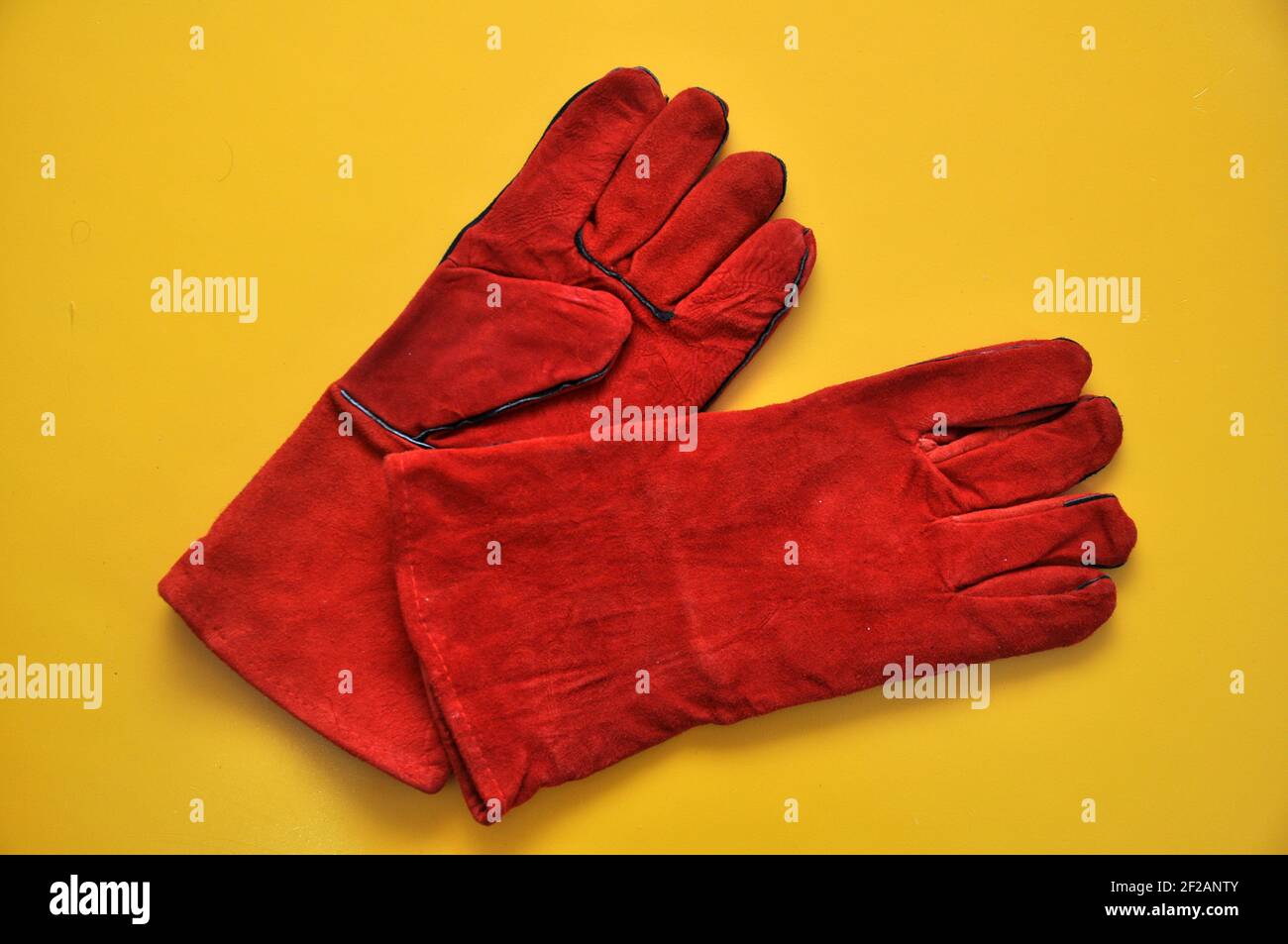 Welder's gloves on a yellow background. Protective accessory for welding. Individual protection means. Stock Photo
