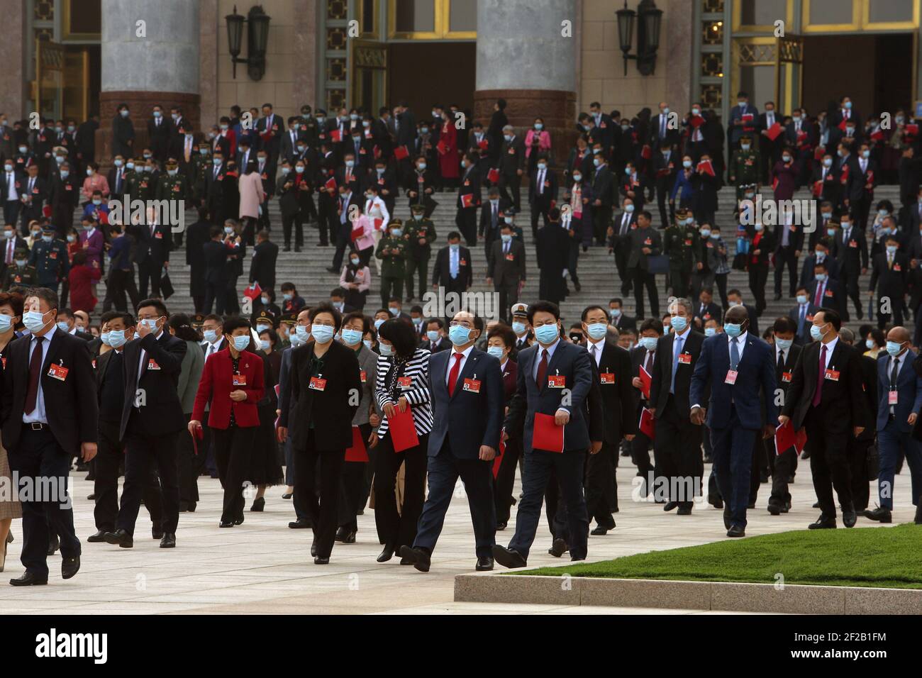 Beijing, China. 11th Mar, 2021. Delegates leave after the end of the closing session of the Fourth Session of the 13th National People's Congress (NPC) being held in the Great Hall of the People In Beijing on Thursday, March 11, 2021. China approved a draft decision to overhaul Hong Kong's electoral system, its latest move to tighten control over the city, by passing the 'patriots governing Hong Kong' resolution at the NPC. Photo by Stephen Shaver/UPI Credit: UPI/Alamy Live News Stock Photo