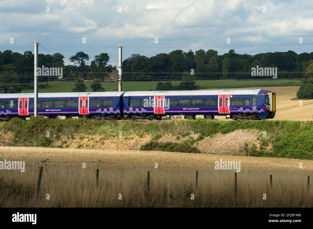 Class 377 passenger train in First Capital Connect livery speeding through the English countryside. Stock Photo