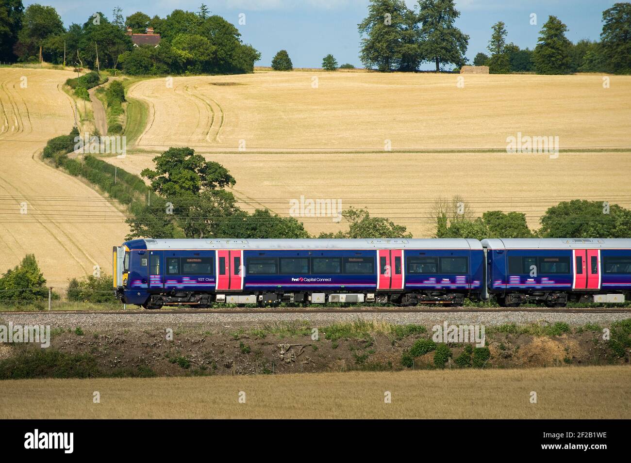 Class 377 passenger train in First Capital Connect livery speeding through the English countryside. Stock Photo