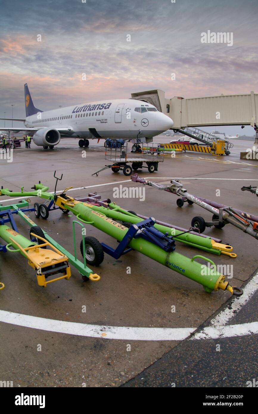 Aircraft tow bars on the apron at Birmingham airport with a Lufthansa Boeing 737 behind. Stock Photo