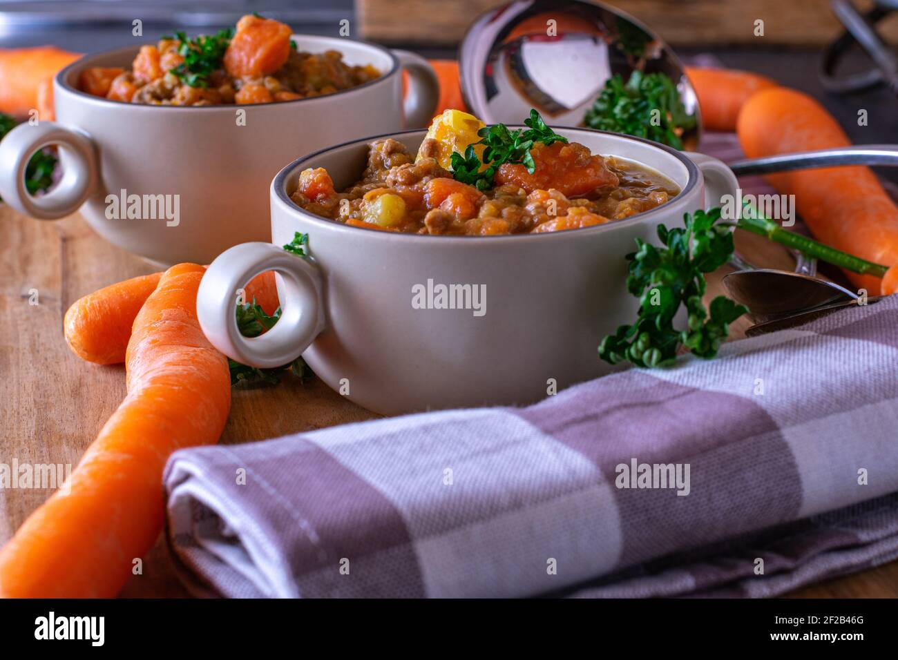 Delicious vegetables legume soup with minced meat in rustic soup cups served on wooden table Stock Photo