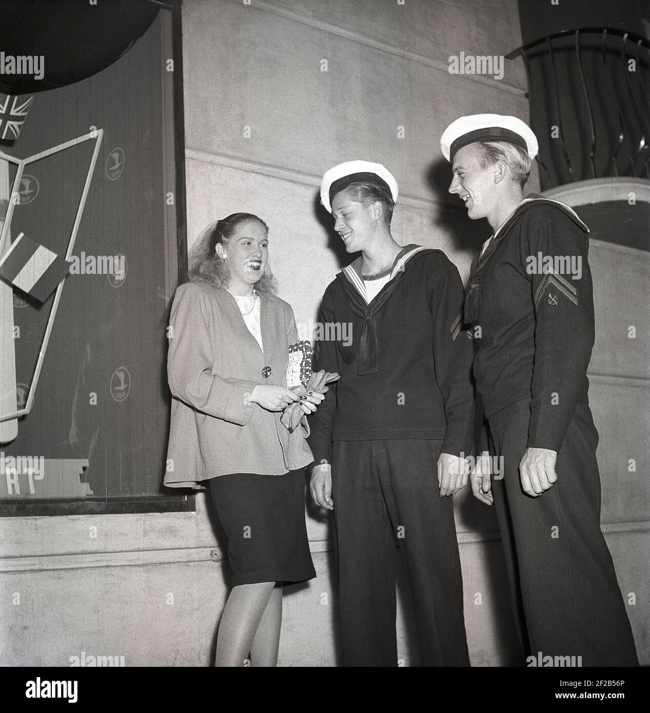 1940s sailors on shore-leave. Two danish seamen in Stockholm talking to a blonde girl on a night on the town. Sweden 1947 ref AD32-5 Stock Photo