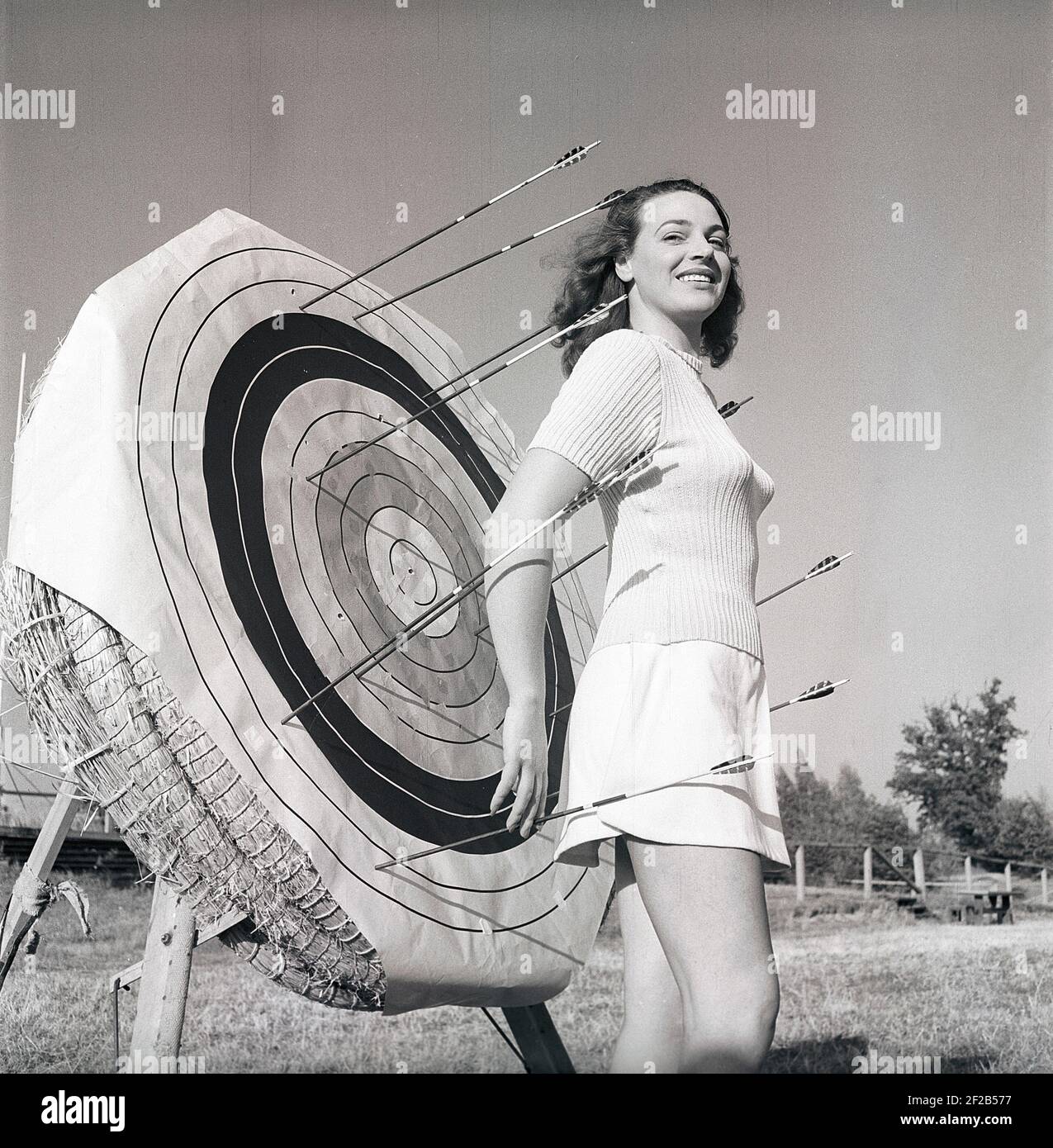 Archery in the 1940s. The young swedish actress Mimi Nelson in front of the target used when shooting arrows. She is dressed in the typical 1940s jumper fashion and a skirt. Sweden 1947 Ref AD7-6 Stock Photo