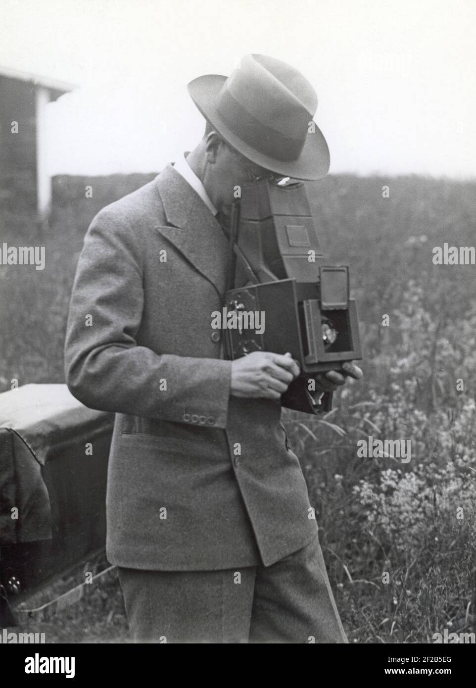 Camera history. Then being the crown prince of Sweden Gustaf Adolf was a keen amateur photographer. Pictured here with his camera aiming it at someone. Sweden 1930s Stock Photo