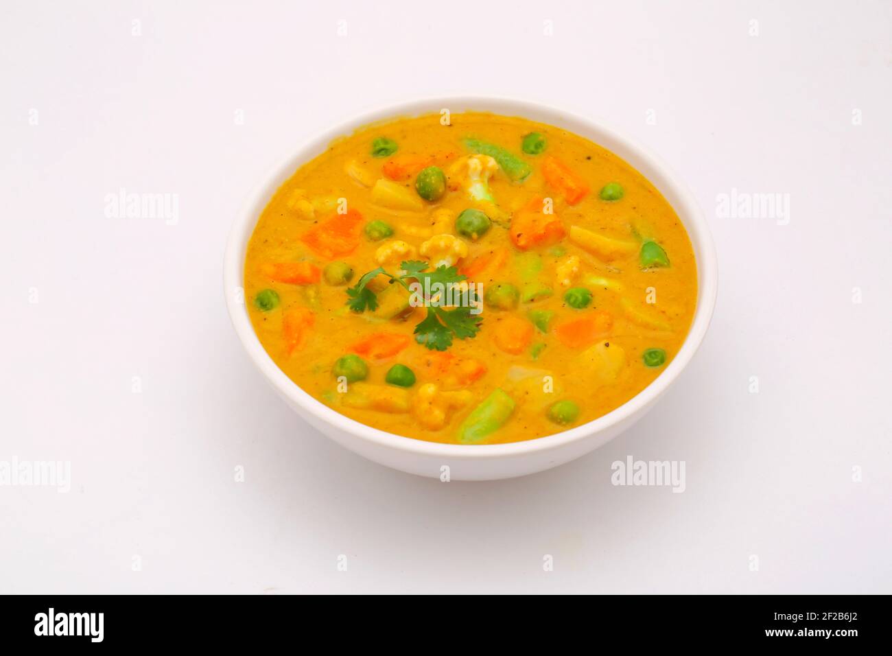 Mixed veg curry or kurma  tasty indian dish made of different vegetables like cauliflower, carrot, potato, green peas and garnished with onion pieces Stock Photo