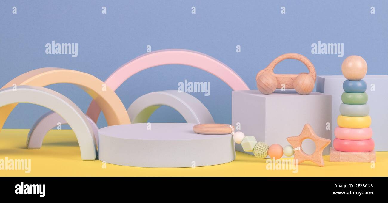 Baby kid toy background. Composition of colorful educational toys and geometric shapes podium, platform on blue and yellow background Stock Photo