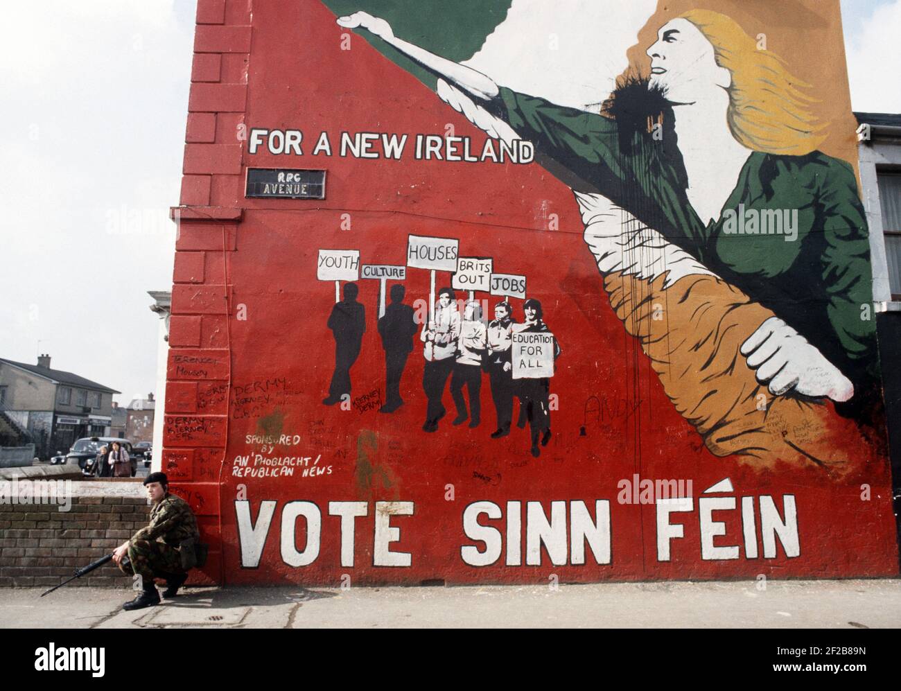 BELFAST, UNITED KINGDOM - OCTOBER 1982. British Army Soldier on corner of Republican Sinn Fein Mural off the Falls Road, West Belfast during The Troubles, Northern Ireland, 1980s Stock Photo