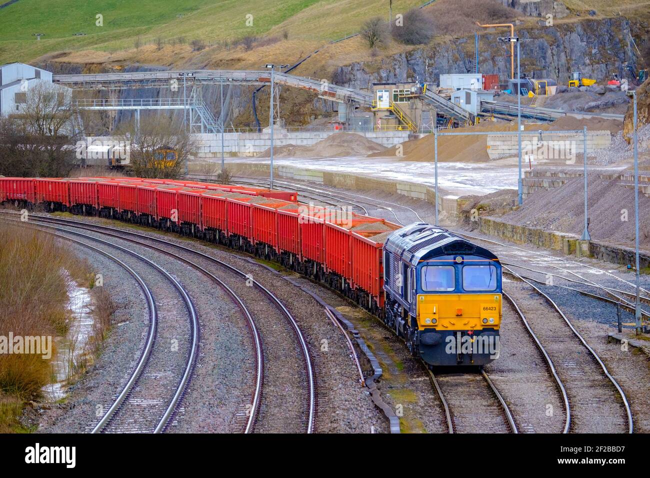 Rail freight moving trucks full of quarry products Stock Photo