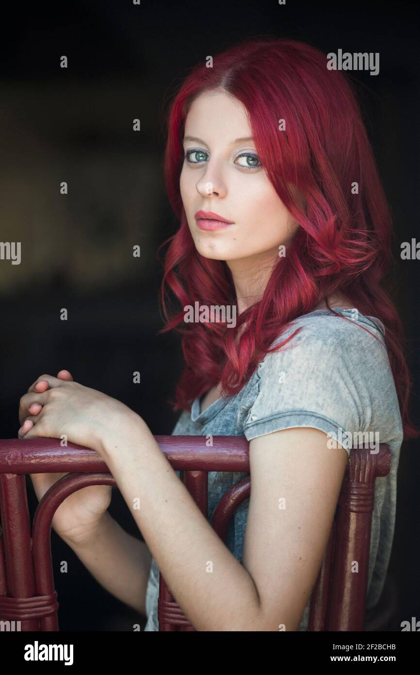 Portrait of a beautiful woman with red hair sitting on a chair Stock ...