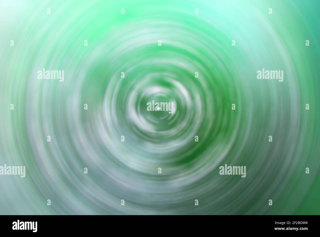 Green concentric colorful circles, abstract blurred vortex, swirl. Stock Photo