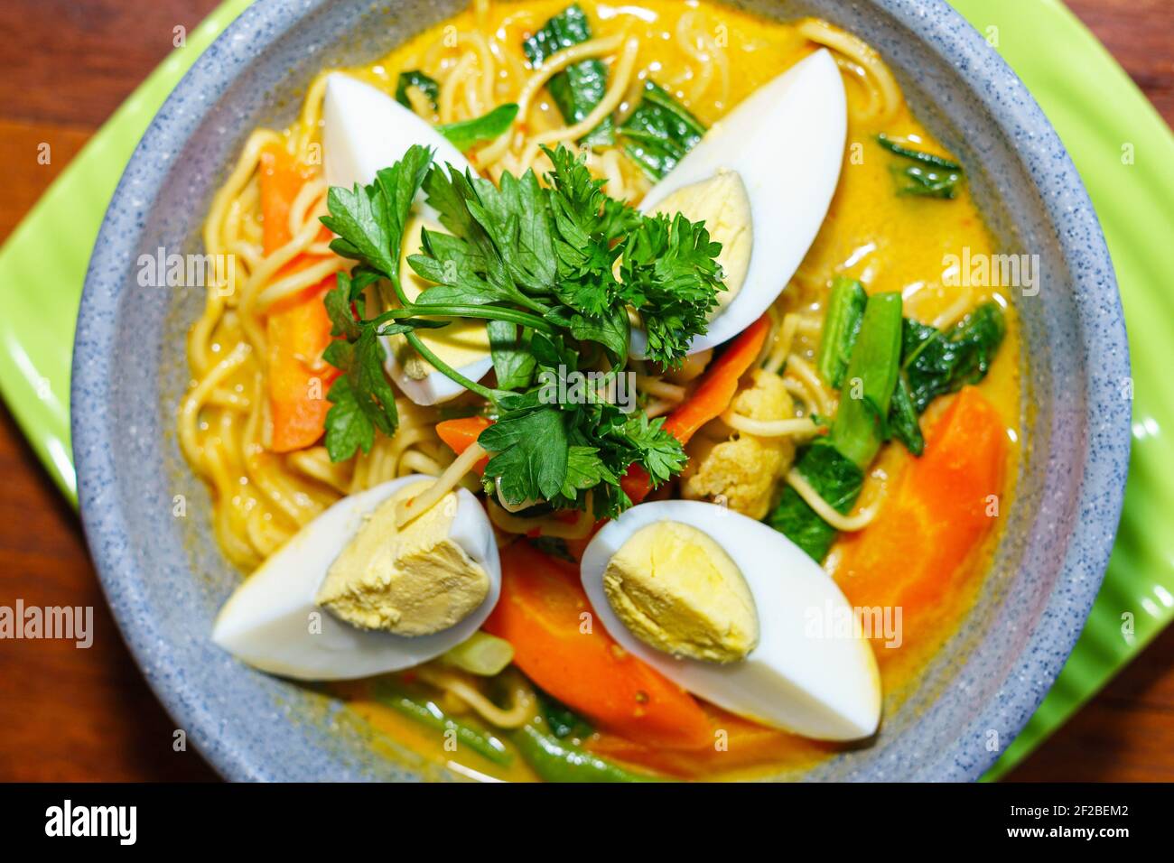 Asian noodle soup with hard boiled eggs and vegetables Stock Photo