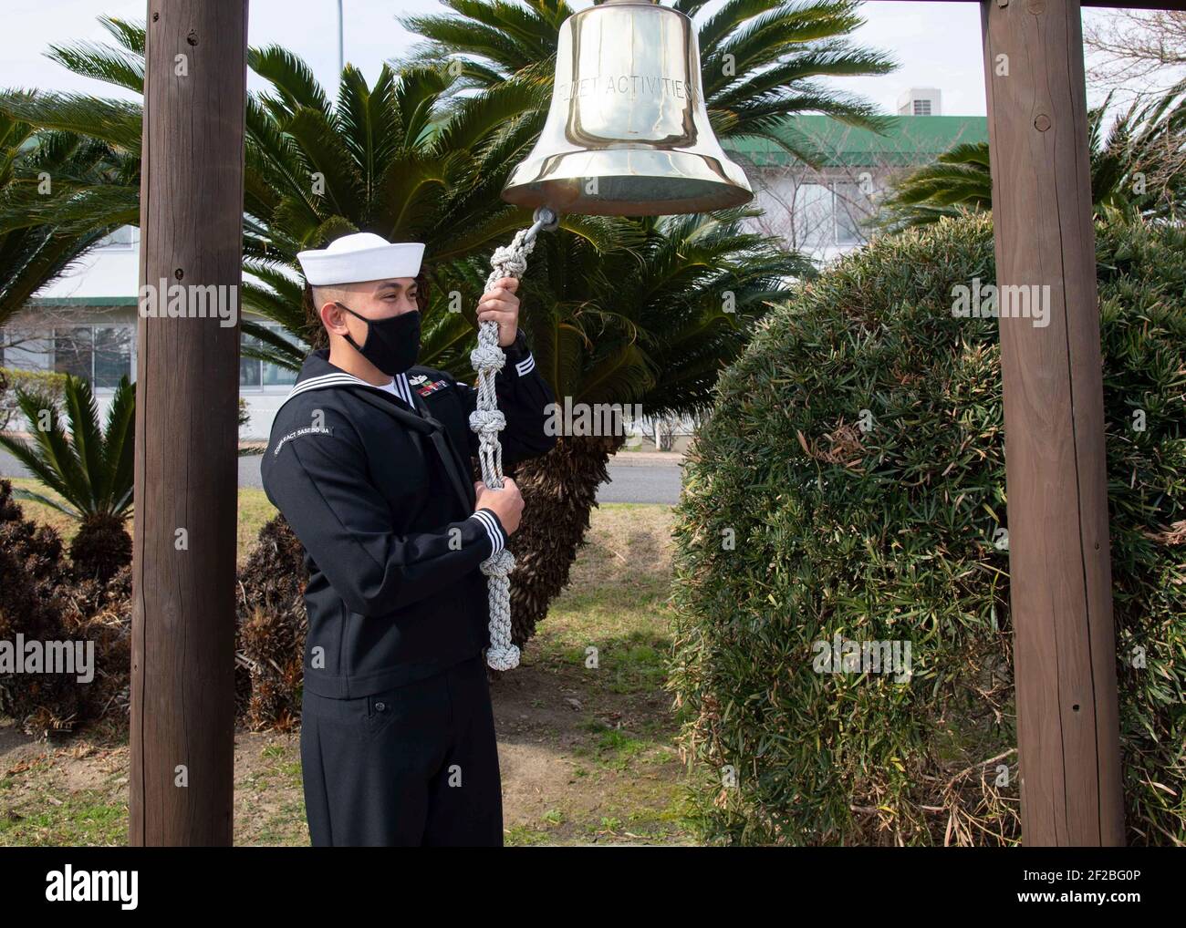U.S. Navy sailor S1C Jonathan Ruelos, assigned to Commander, Fleet Activities Sasebo rings a bell to mark the tenth anniversary of the Great Tohoku Earthquake and Tsunami disaster March 11, 2021 in Sasebo, Japan. The earthquake and ensuing tsunami resulted in the deaths of 15,884 people across 20 prefectures in Japan. Stock Photo