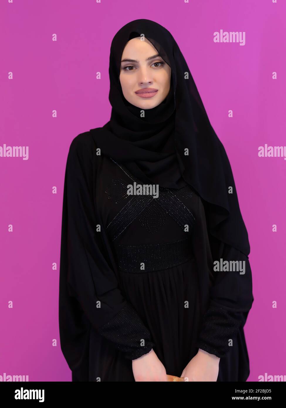 Portrait of young muslim woman wearing hijab isolated on pink ...