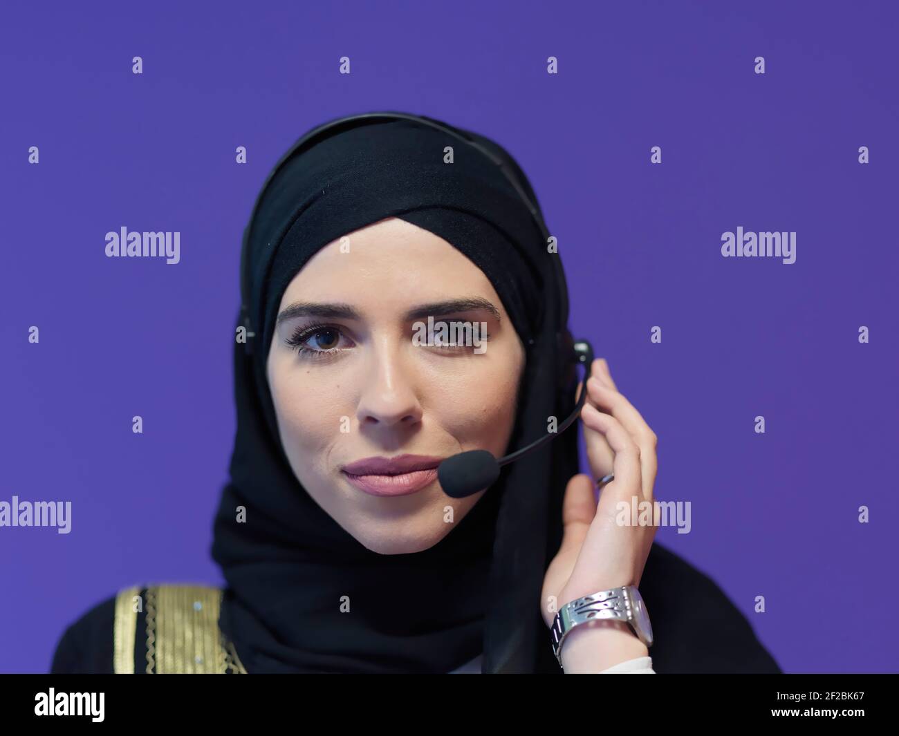 Portrait of young muslim woman with headphones working as call center ...
