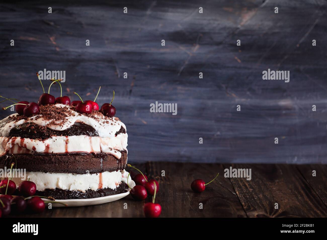 Delicious Black Forest Cherry Cake, Schwarzwald pie dessert, over a dark rustic wood table. Selective focus with blurred background and free space for Stock Photo