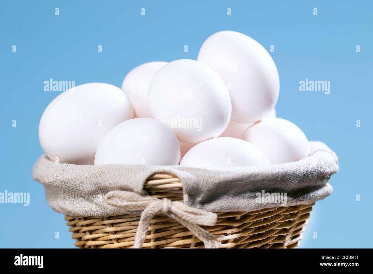 Chicken Eggs in a straw Basket, A lot of White Fresh Raw eggs in a container, Natural Eko Product, Easter preparing Copyspace Stock Photo