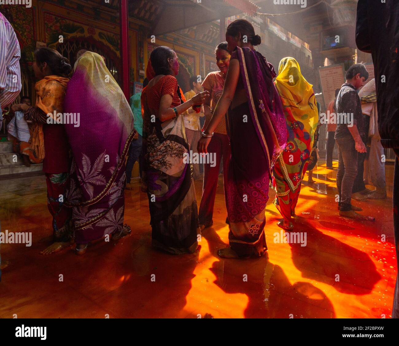 India, Mathura - Devotees celebrate Holi inside Dwarkadheesh  temple. Stock Photo