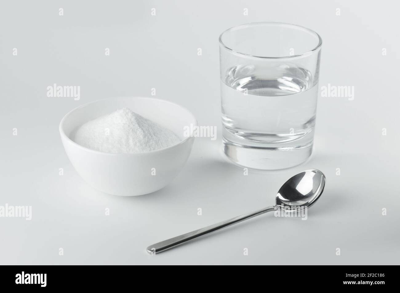 Baking soda, spoon and glass of water. Spoon of baking soda and glass