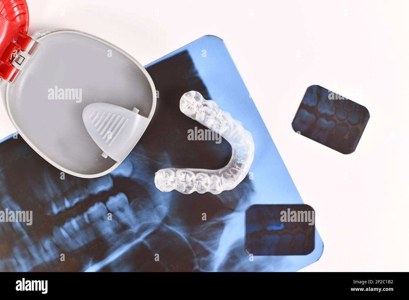 Transparent customized teeth bite guard clear aligners for lower jaw with storing case with dental X-ray Stock Photo