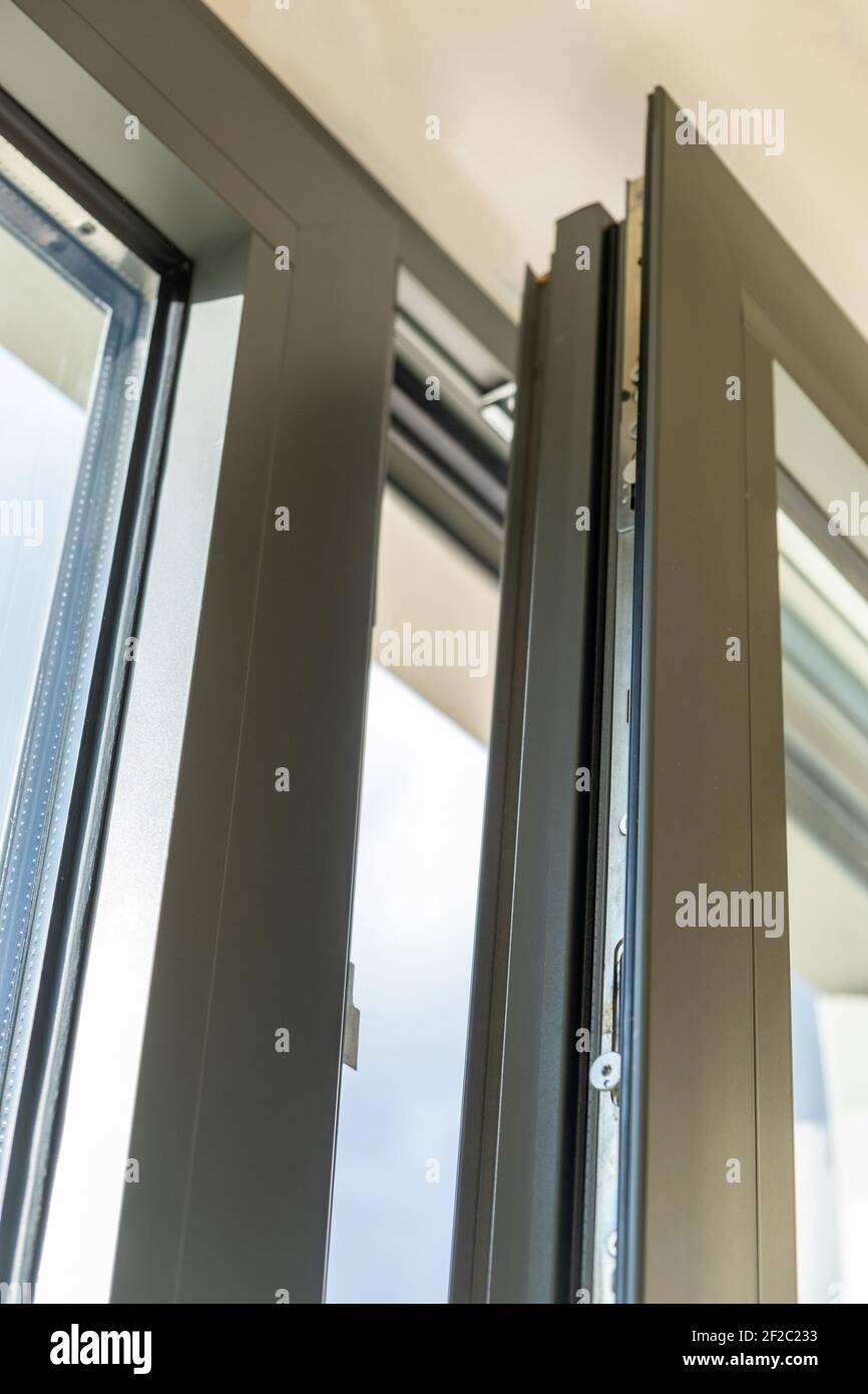 Window aluminum open detail. Metal or PVC door frame vertical closeup view. Energy efficient, security profile, Tilt and turn window, fresh air for ho Stock Photo