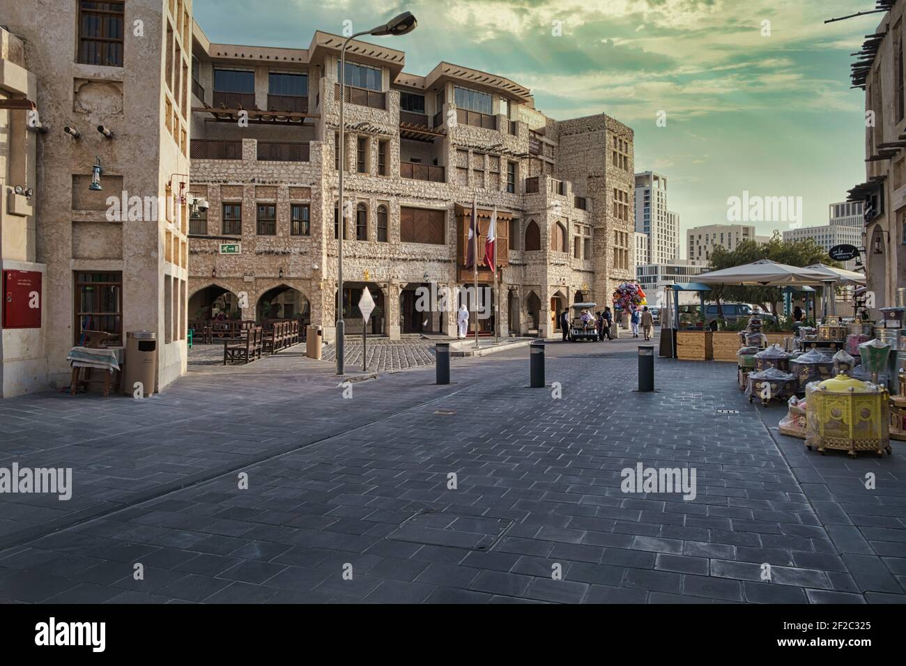 Souq waqif in Doha Qatar daylight view showing traditional Arabic architecture , Qatar flag and people in the street Stock Photo