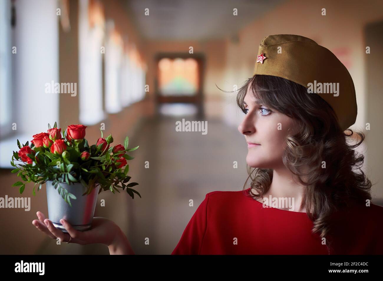 Woman in military uniform USSR with a bouquet of roses. Victory day in honor of the end of world war II. Holiday dedicated to the second world war in Stock Photo