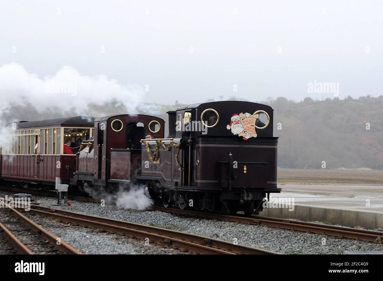 'Taliesin' leads 'Prince' across 'The Cob' into Porthmadog Harbour station with a return 'Santa Special' from Tan Y Bwlch. Stock Photo