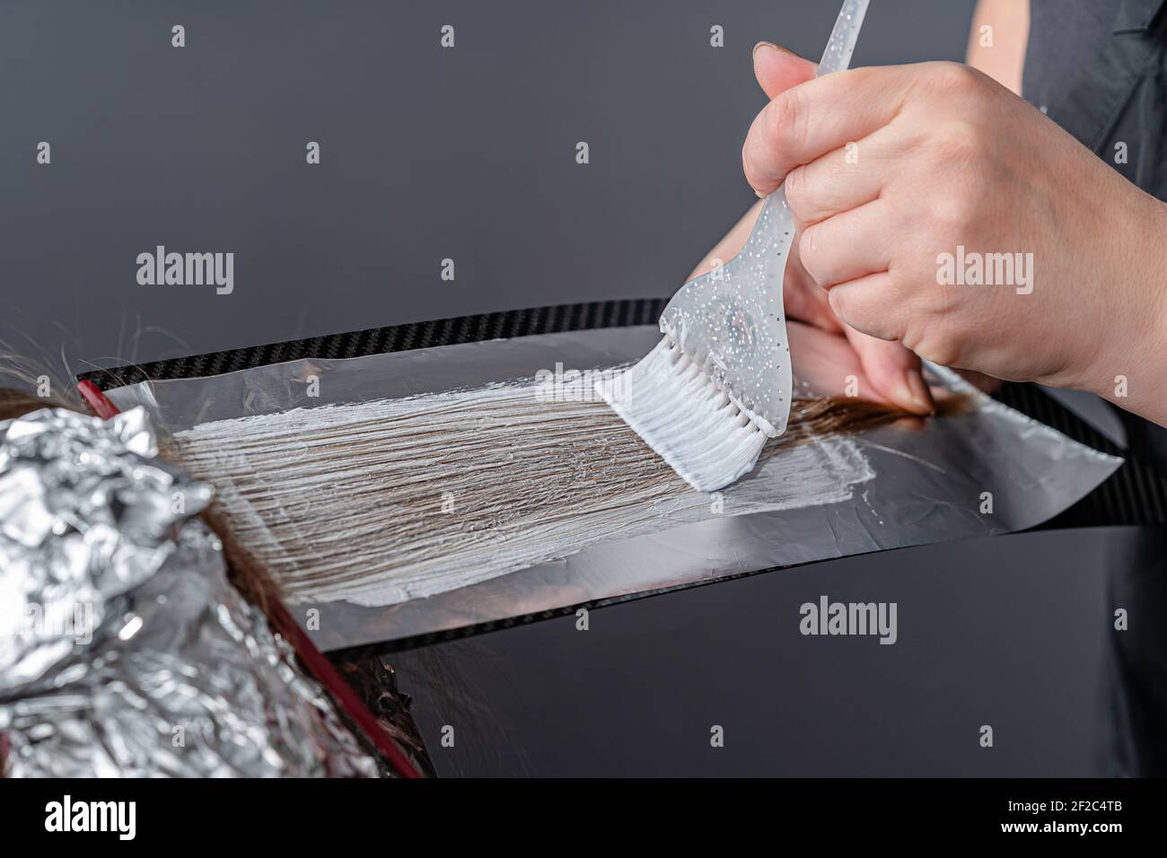 Process of applying bleaching powder on clients hair and wrapping into