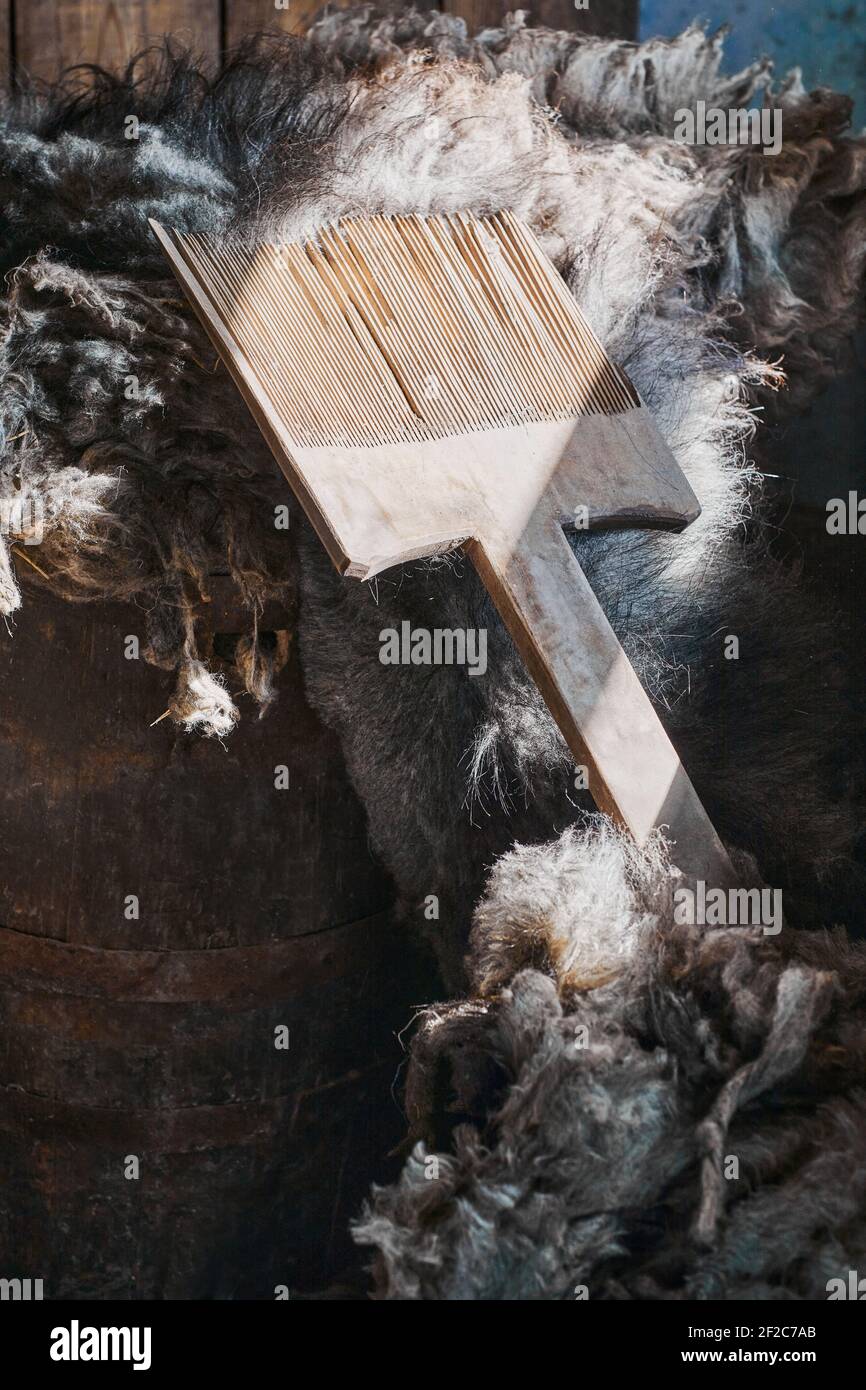 An artificial wooden tool for combing sheep wool  for yarn and weaving. Handmade manufacturing concept Stock Photo