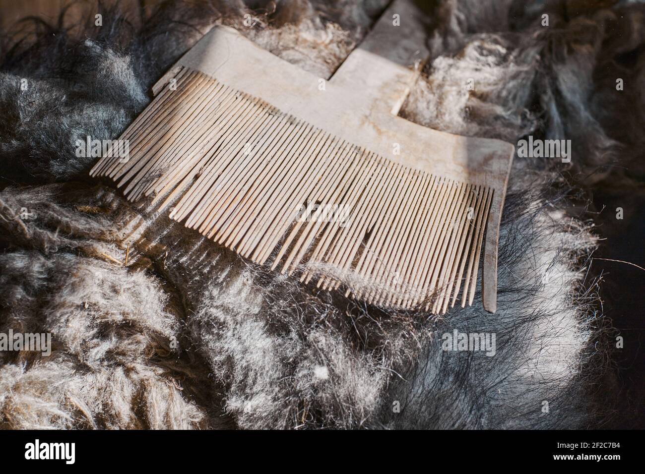 An artificial wooden tool for combing sheep wool  for yarn and weaving. Handmade manufacturing concept Stock Photo