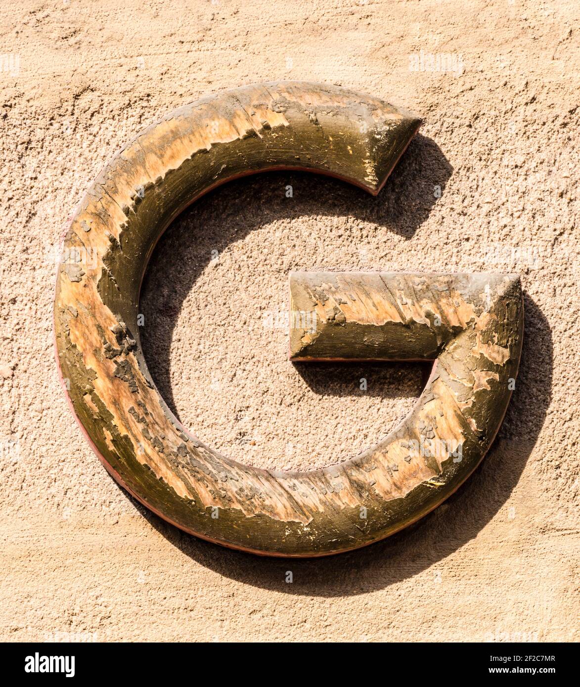 Weathered gilt capital letter G Stock Photo