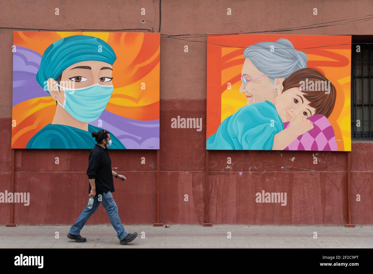 Santiago, Metropolitana, Chile. 11th Mar, 2021. A pedestrian passes in front of a painting made in tribute to health personnel. Credit: Matias Basualdo/ZUMA Wire/Alamy Live News Stock Photo