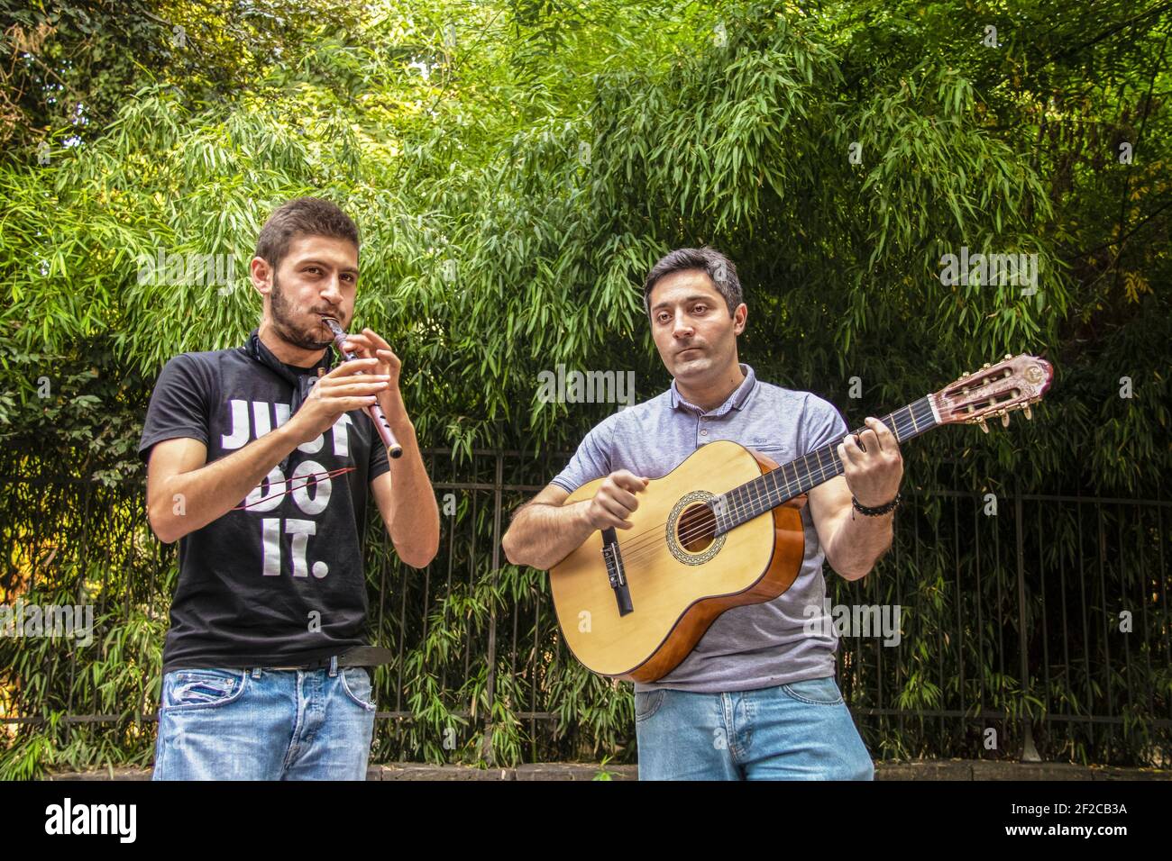 7-19-2019 Tbilisi Georgia Two young men in jeans playing traditional Georgian music outside with guitar and stviri or flute Stock Photo