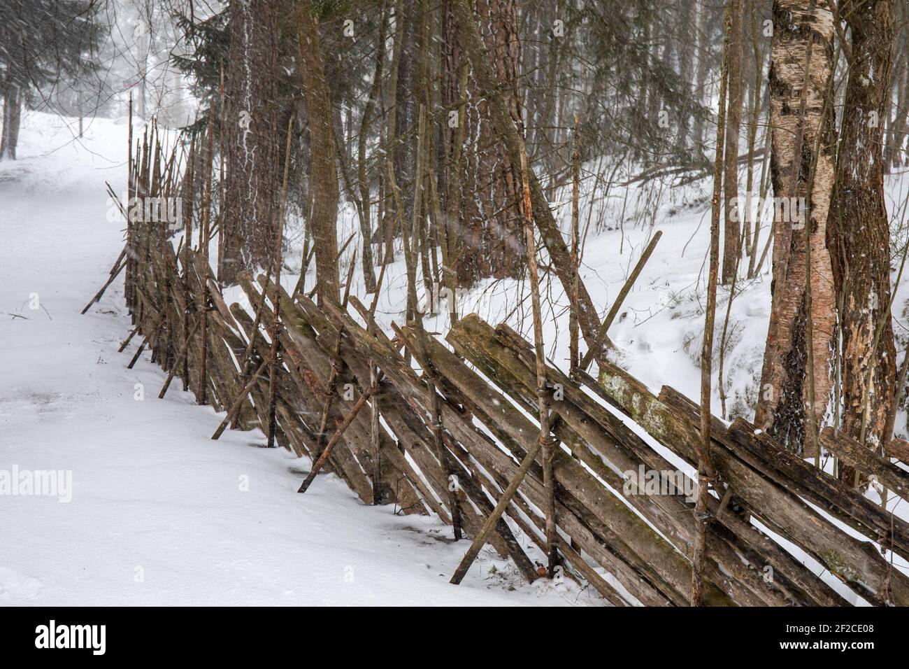 Traditional Nordic wooden roundpole fence in Seurasaari Open-Air Museum during winter in Helsinki, Finland Stock Photo